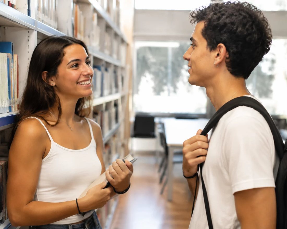 Dois participantes sentados de frente um para o outro numa rodada de réplica, na sala da escola no São Paulo
